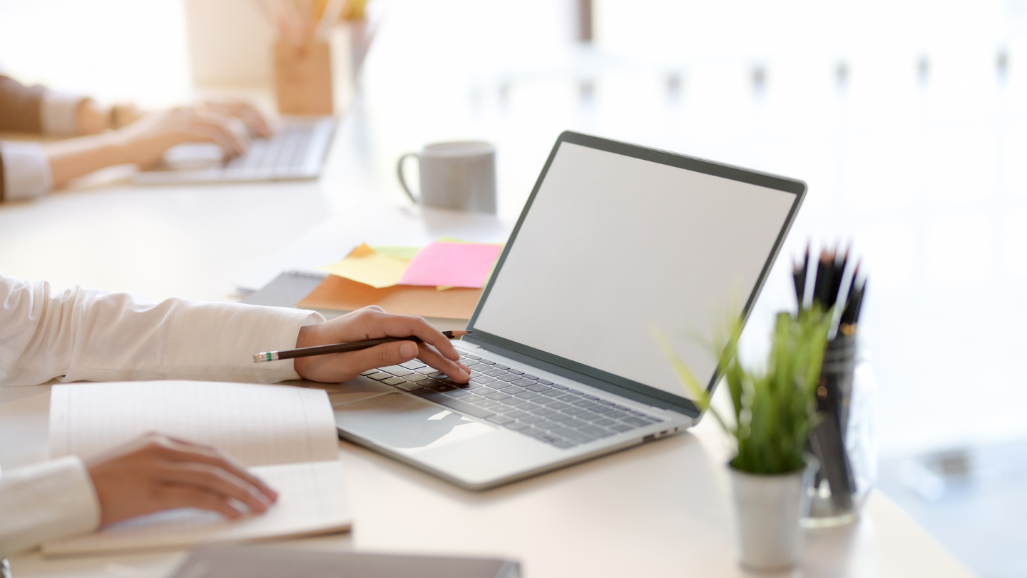 Crop person working with laptop in office